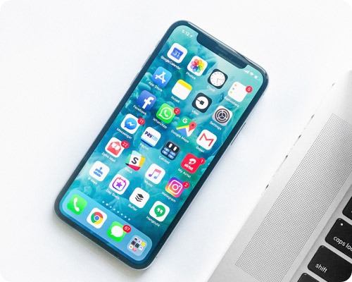 Phone on a desk next to a laptop