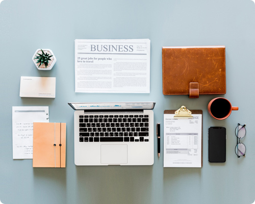 Laptop and newspaper on desk